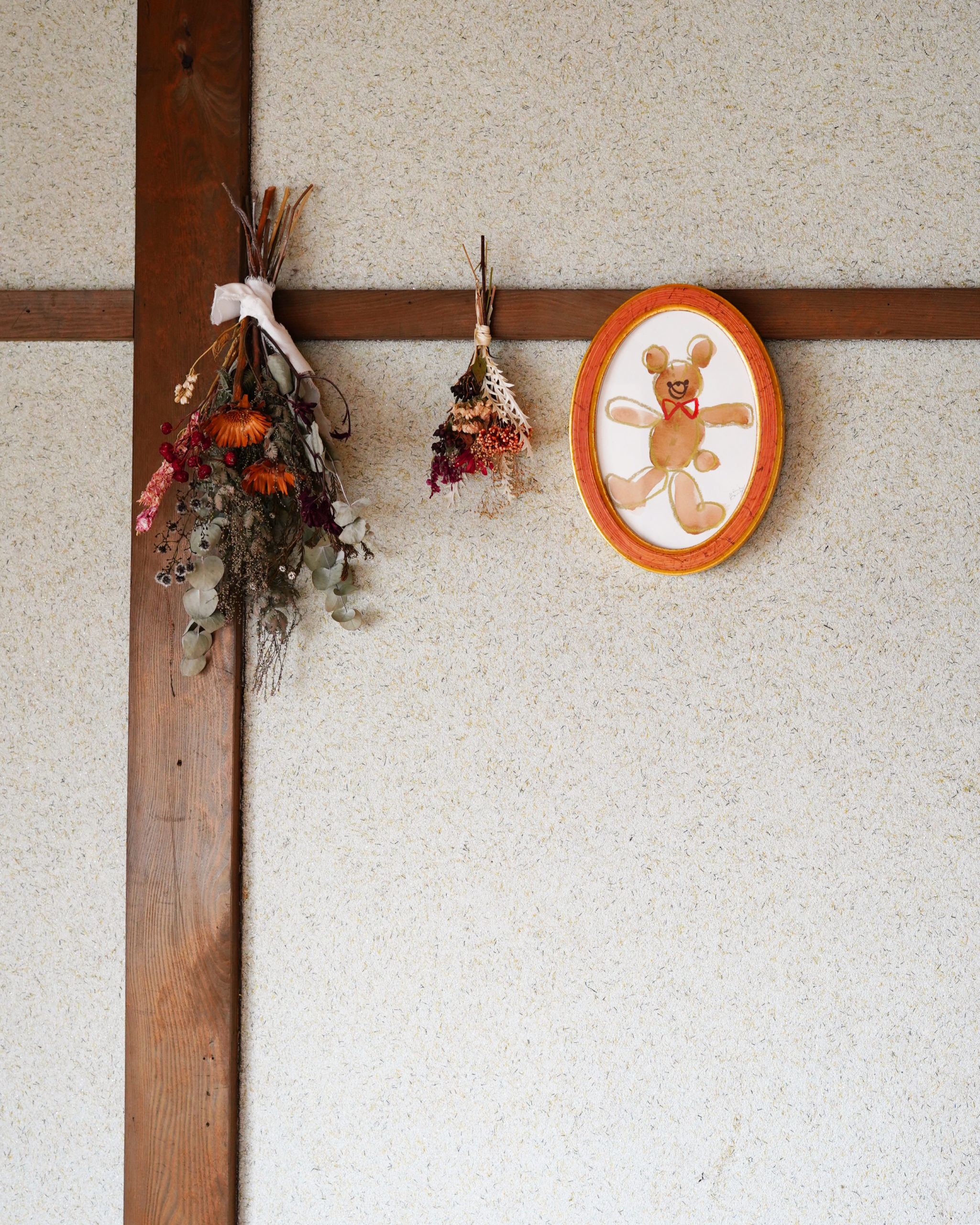 パン教室FUKURAの土壁に飾っているドライフラワーのスワッグとくまのイラスト